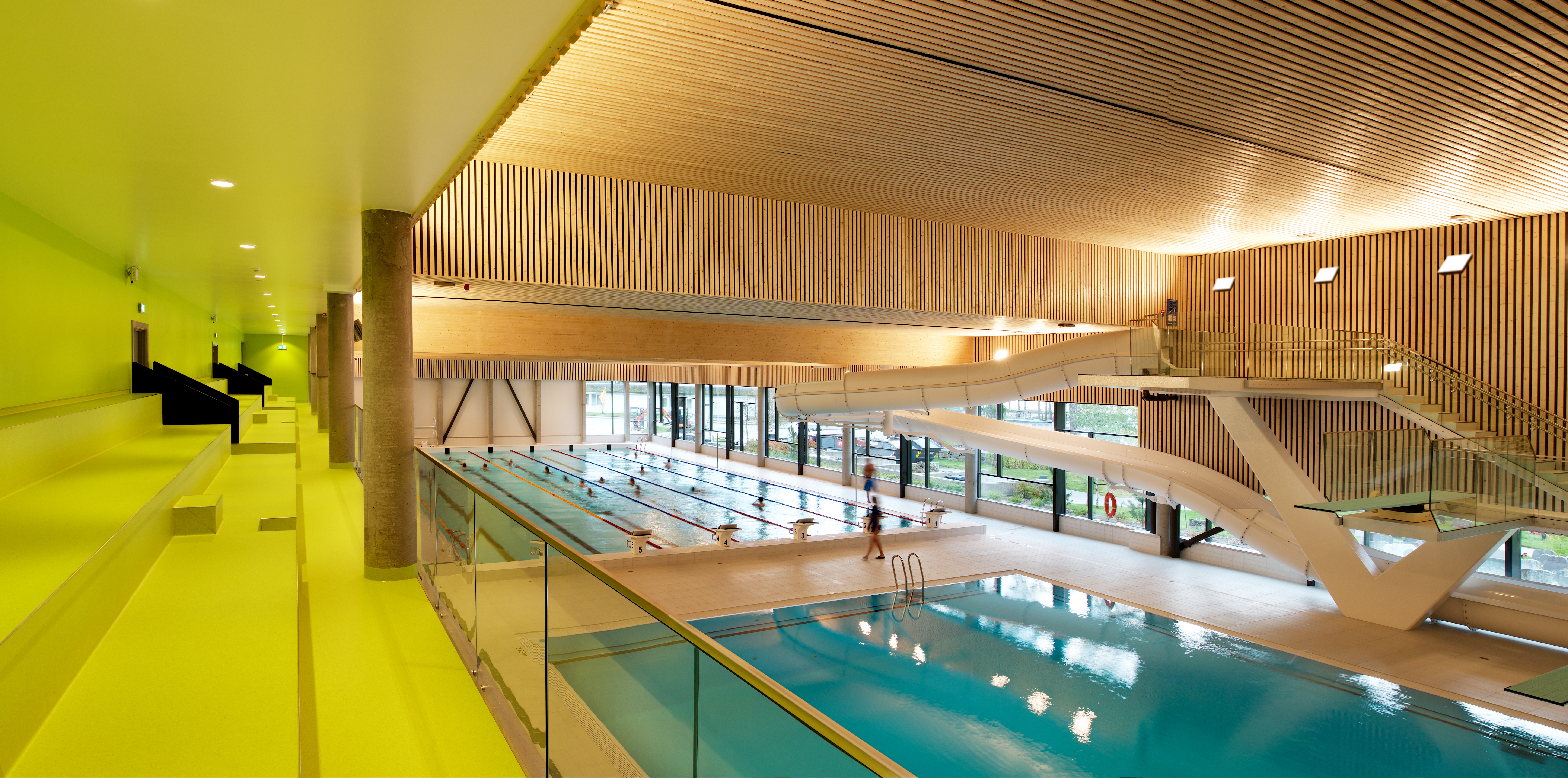 Vossabadet har tre basseng: eit treningsbasseng, eit stupebasseng og eit opplæringsbasseng. Her kan ein sjå to av dei frå tribunen. Foto: Pål Hoff, HLM Arkitektur. 