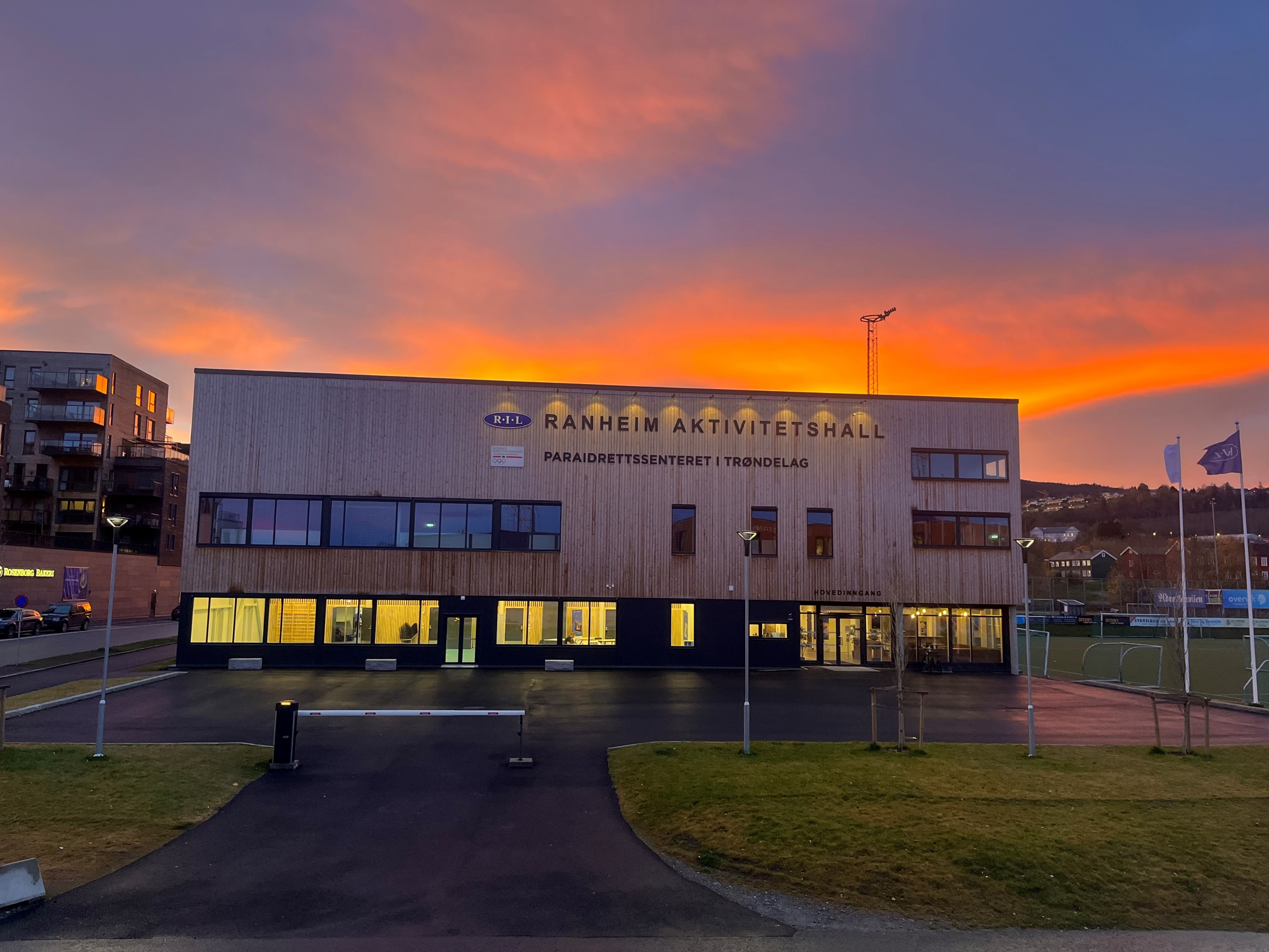 Fasadebilde av Ranheim Aktivitetshall og Paraidrettssenteret i Trøndelag i solnedgang