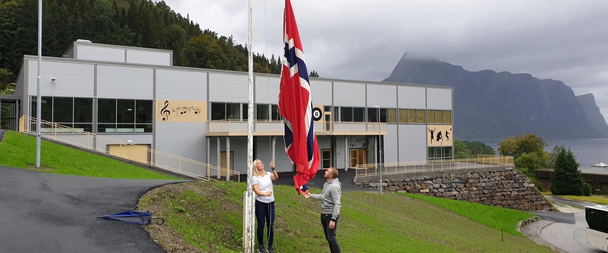 Det norske flagget skal heises opp av to personer utenfor Hyllestadhallen.