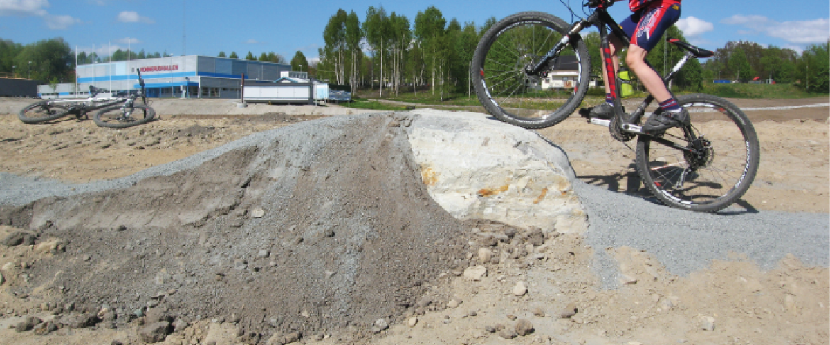 Syklist som forserer et hinder av stein og grus
