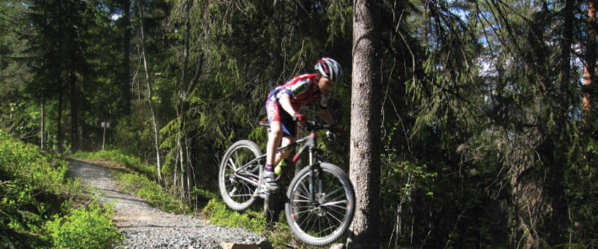 Syklist hopper i skogen