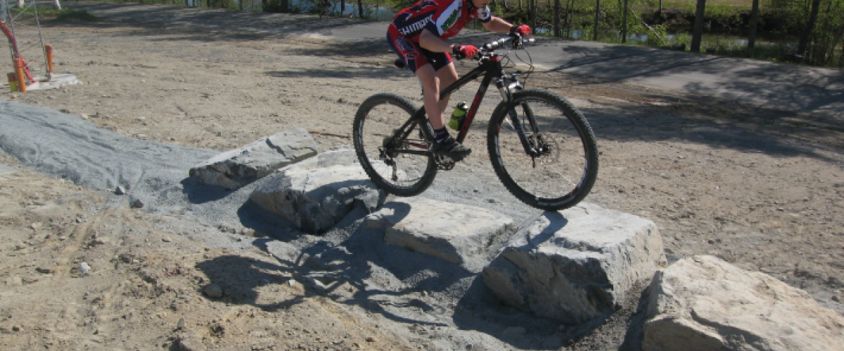 Syklist som sykler over små stenblokk