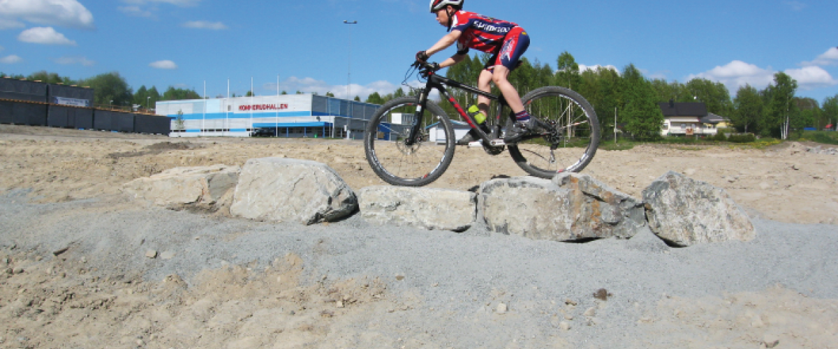 Syklist som sykler over små steinblokk