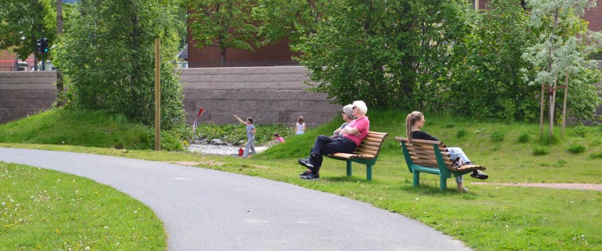 Benker i parken med personer som hviler seg.