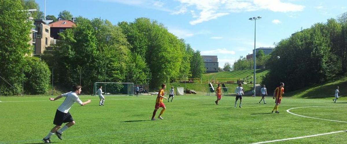 To lag spiller fotballkamp på kunstgressbane
