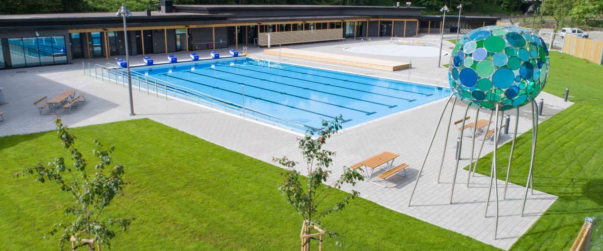 Utendørs svømmebasseng med grøntområder