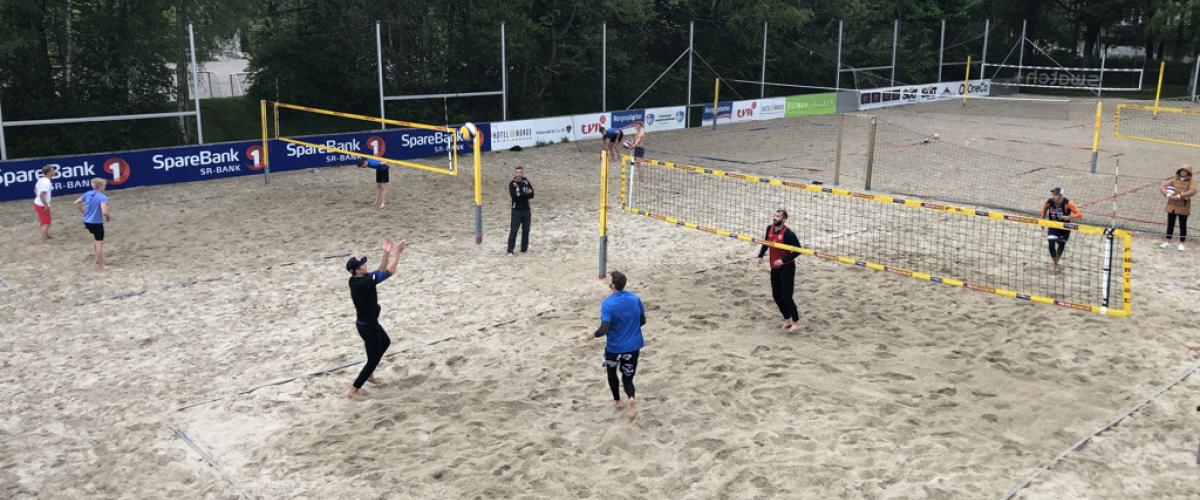 Spillere som spiller sandvolleyball på utendørsbaner