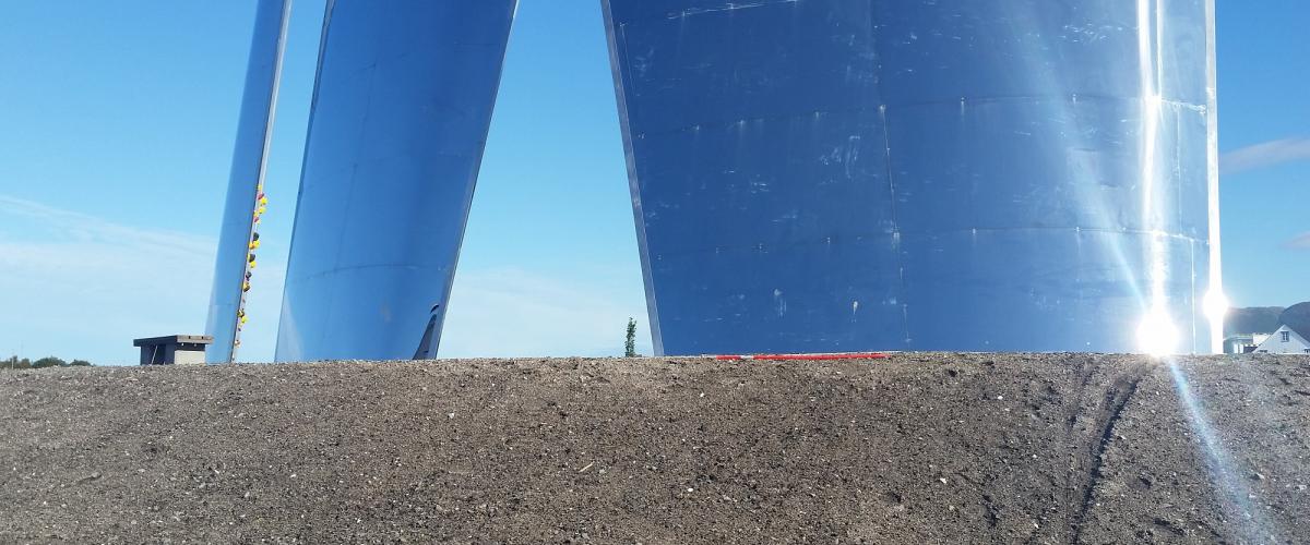 Tre skrå seil av betong og plankpolert stål med klatretak