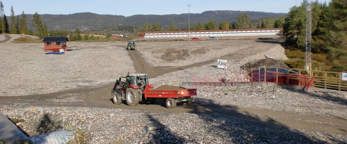 Traktorer kjører stein og grus ut på skistadion