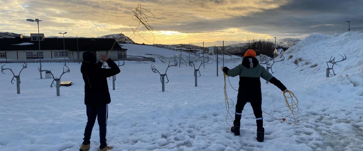 Barn laster gul lasso på reinsdyrstativ