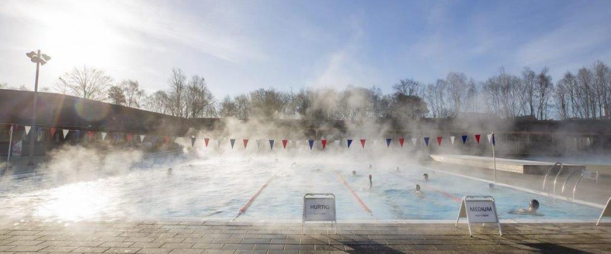 Utendørs svømmebasseng med vanndamp i lufta