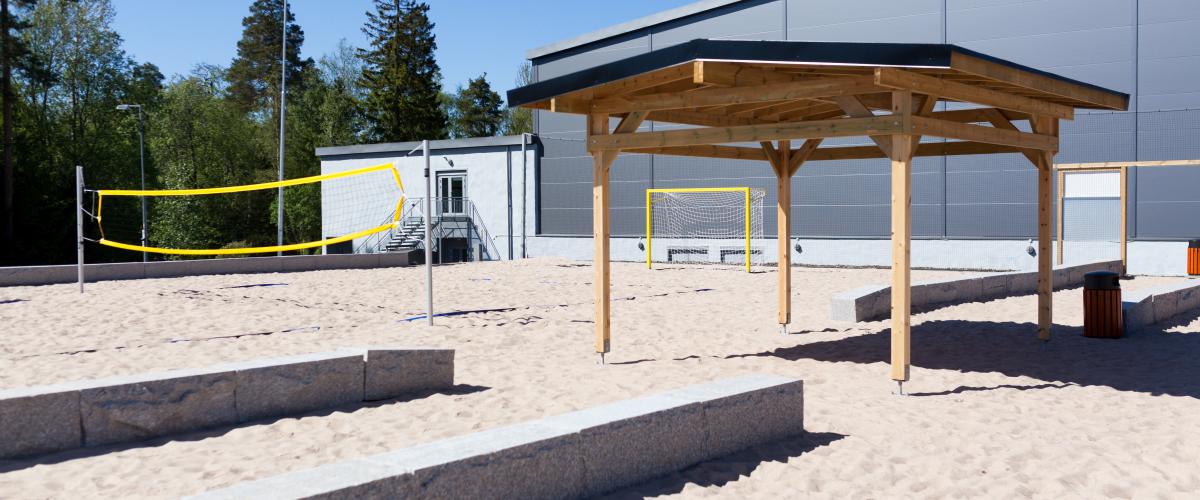 Benker og tak over hode mellom de to beachhåndballbanene