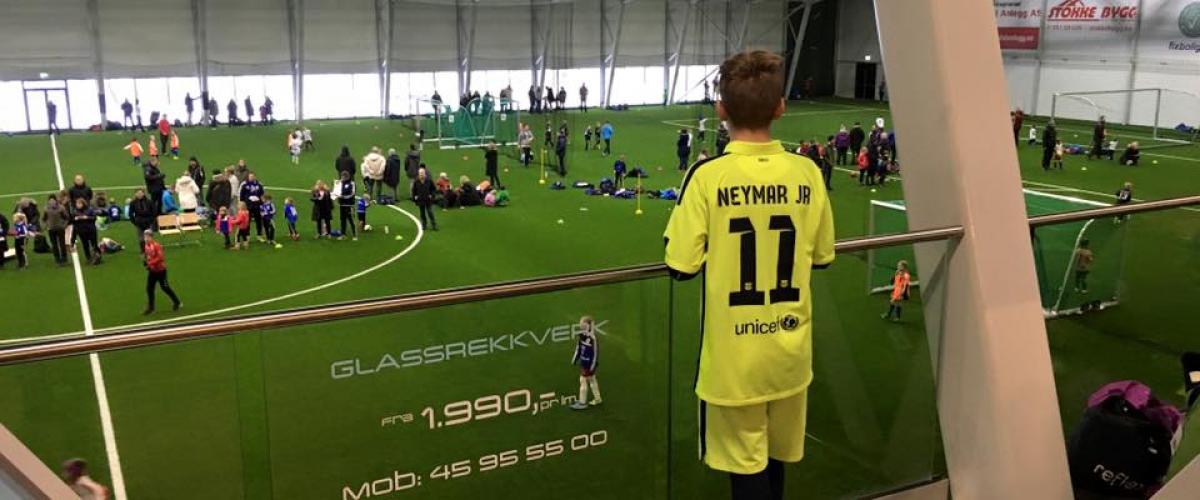 Gutt som ser ned på fotballbanen i Vestfoldhallen.