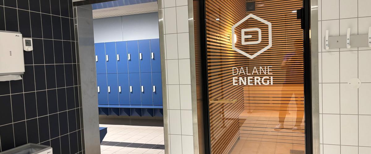 bildet viser en del av garderoben med blå garberobeskap til venstre og inngang til badstue til høyre